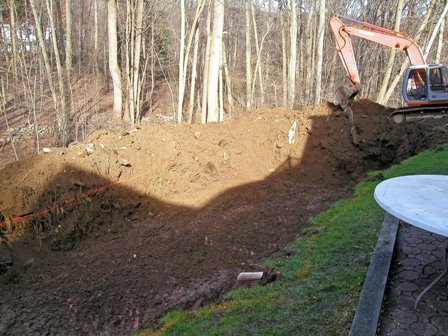 Backhoe digging hole for pool
